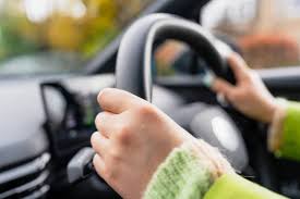 Learner driver hands on the steering wheel during a lesson
